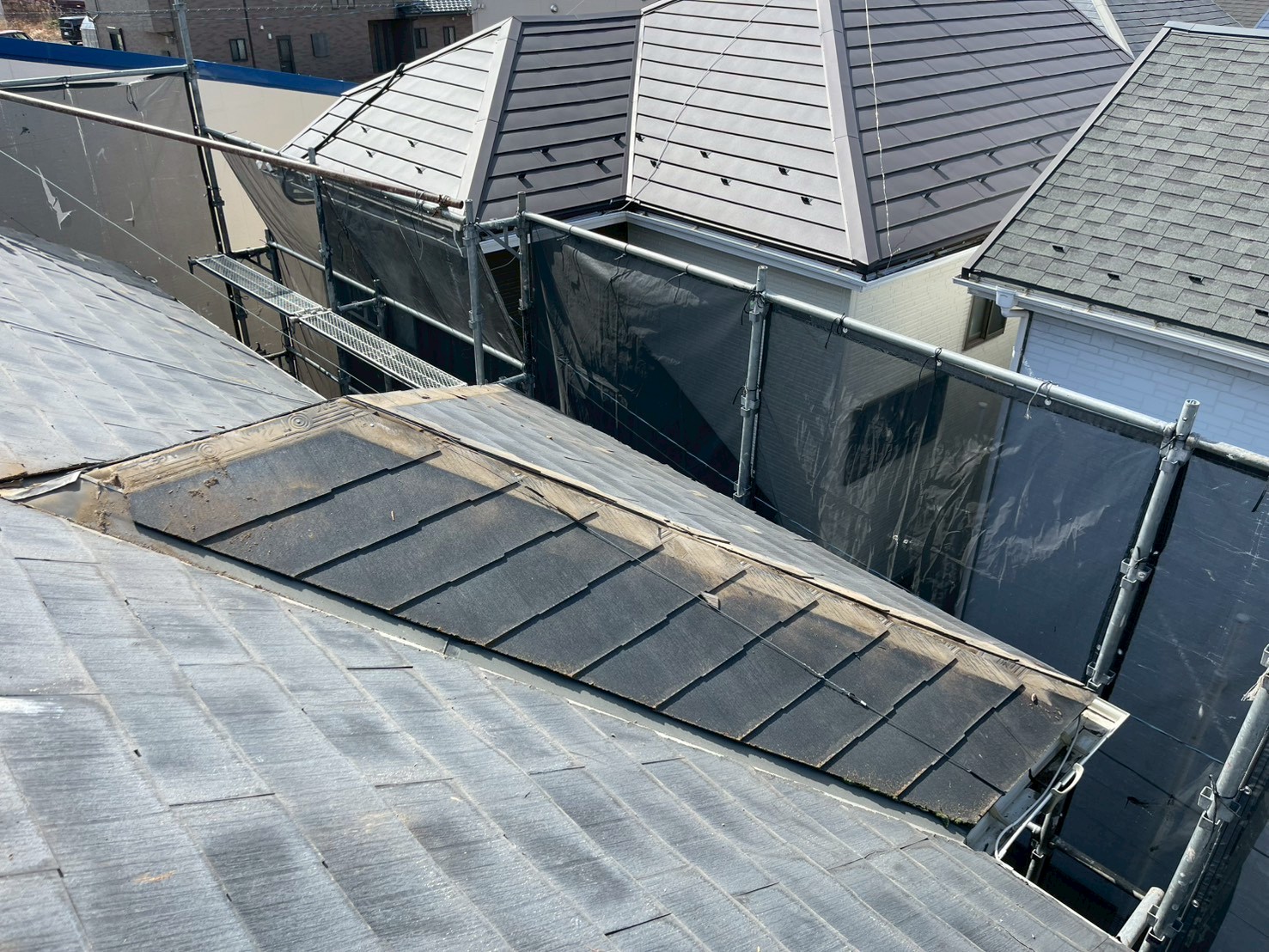 複雑な屋根形状の古びたスレート屋根